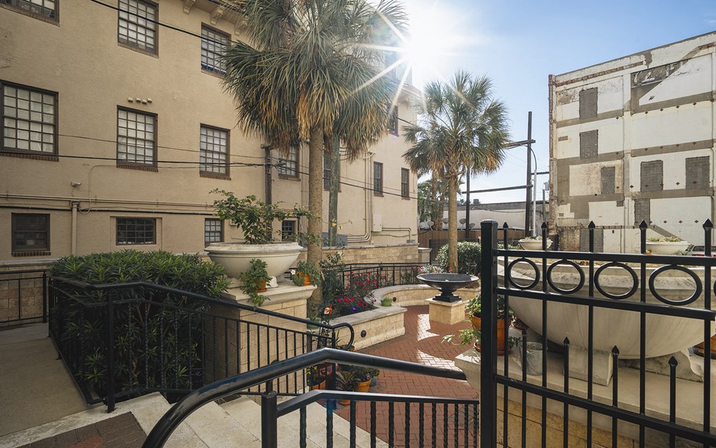 a balcony with a view of a building and some palm trees