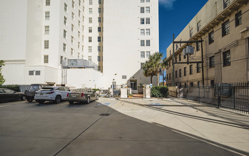 a parking lot with cars parked in front of a tall building