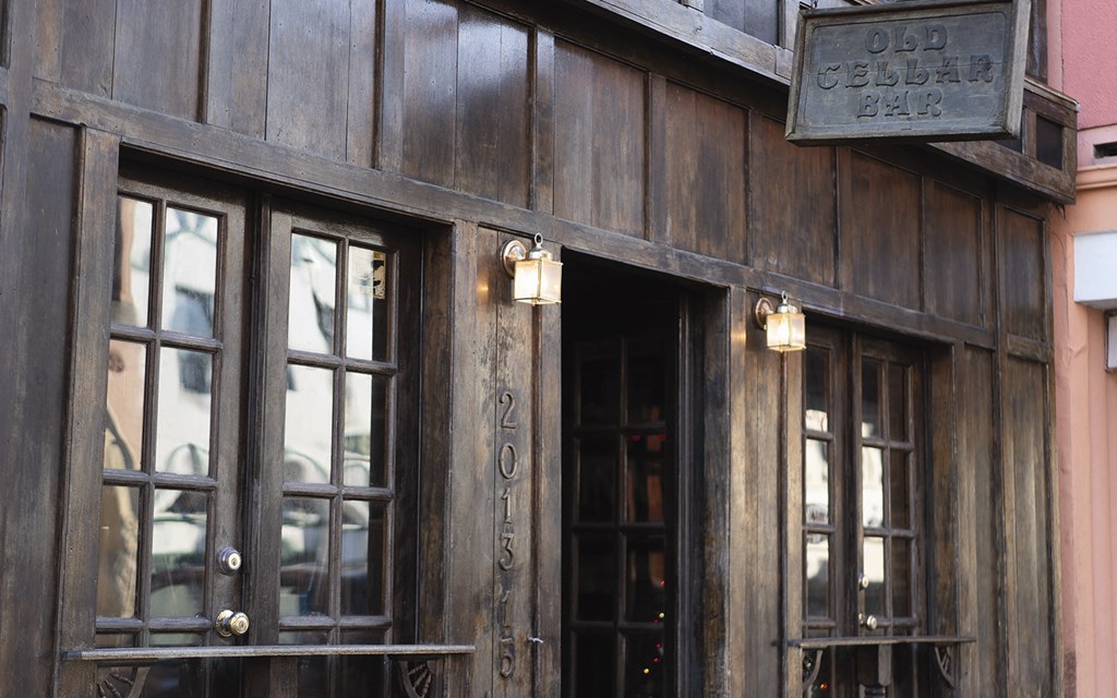 the front of a restaurant with wooden walls and windows