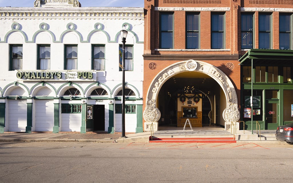 a city street with a building with an arch in front of it