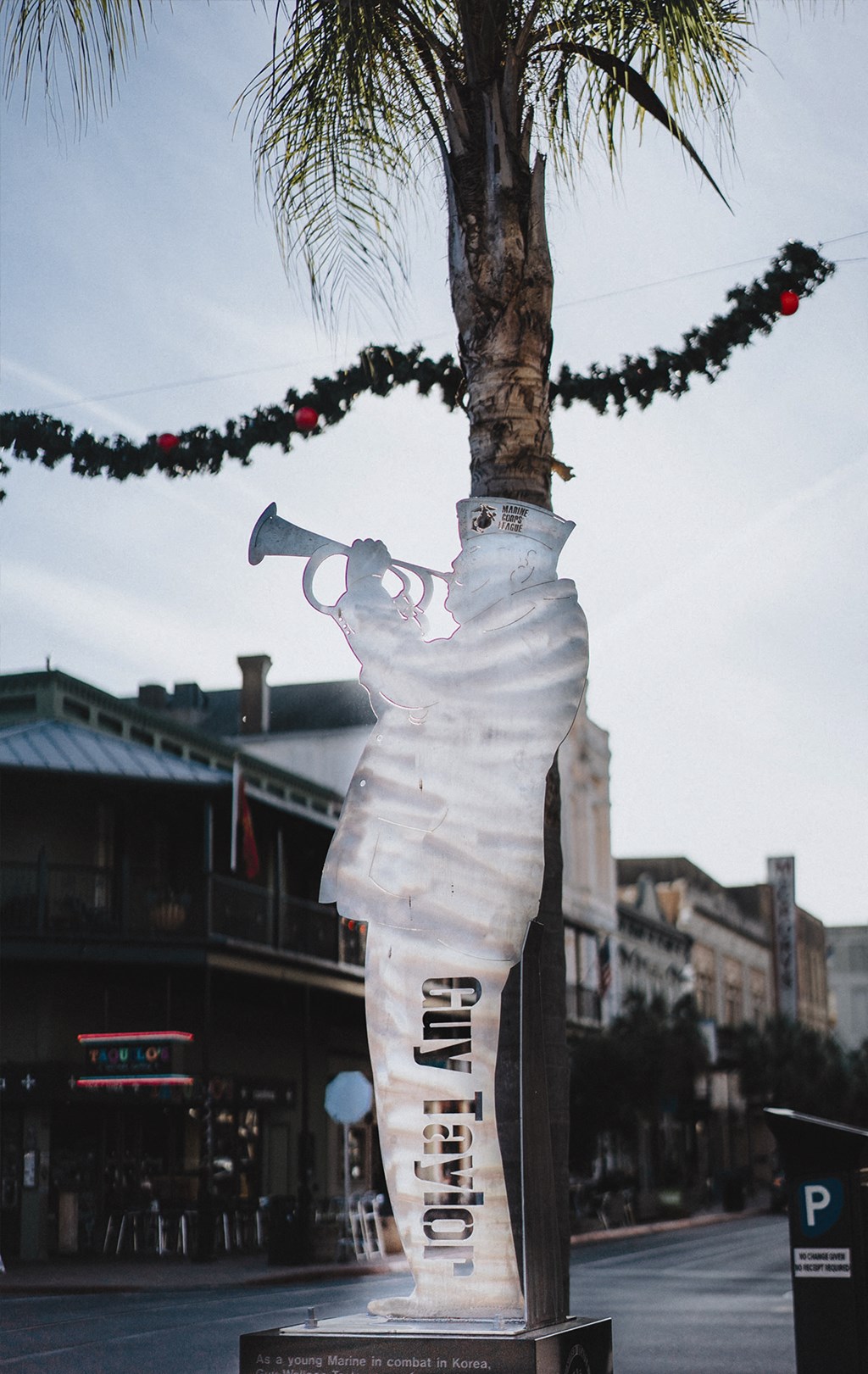 a statue of a person holding an axe on a palm tree