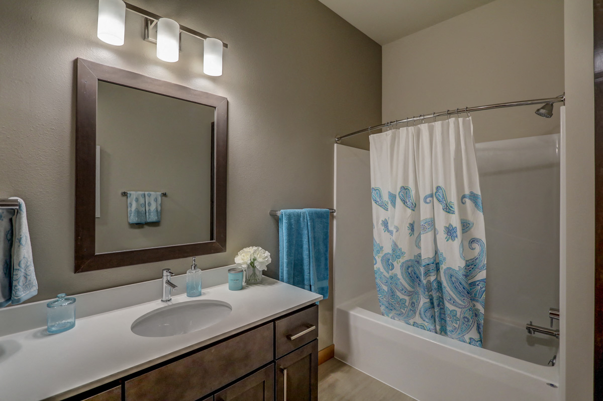 a bathroom with a sink and a shower and a mirror