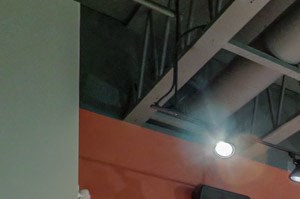 a group of spin bikes in a gym with a wall of monitors