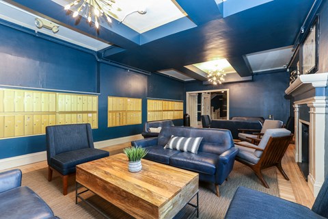 a lobby with blue walls and leather furniture and a wooden table