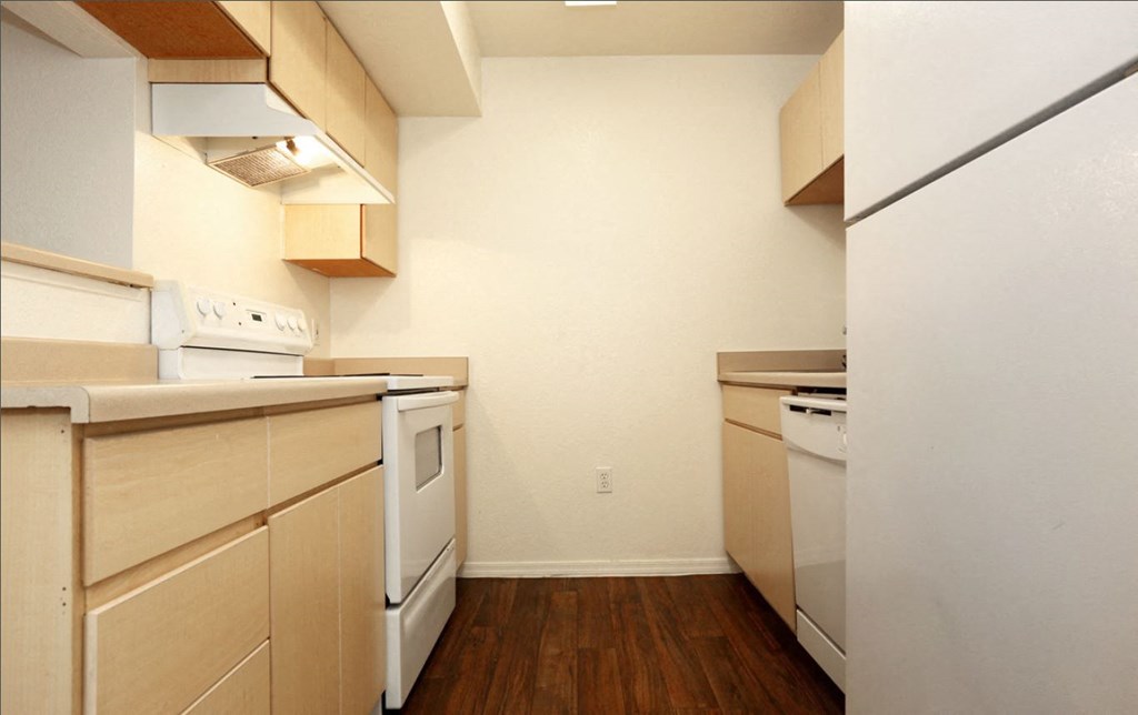 a kitchen with white appliances and wood flooring