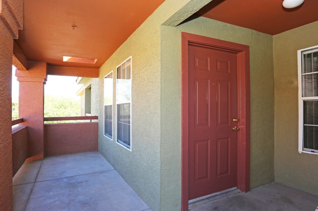 the front door of an apartment building with a porch