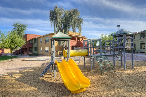 a playground with a yellow swing set and slides