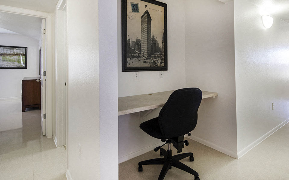 a desk in a home office with a chair