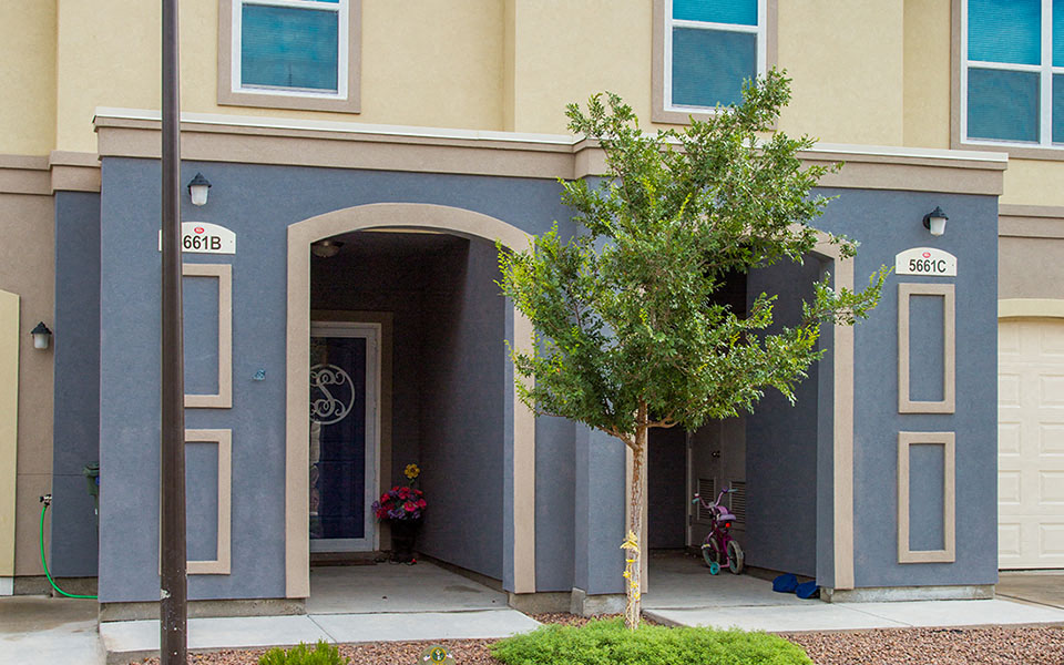 a blue building with a tree in front of it