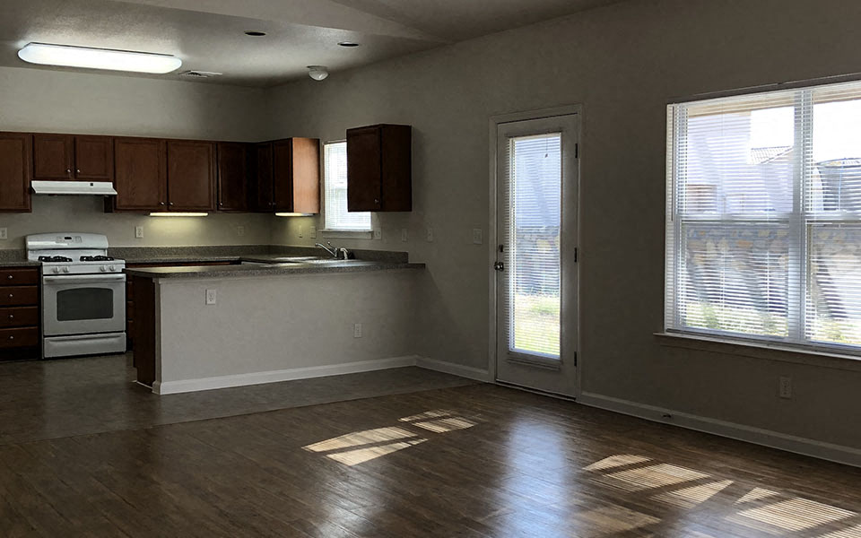 an empty kitchen with a stove and a door