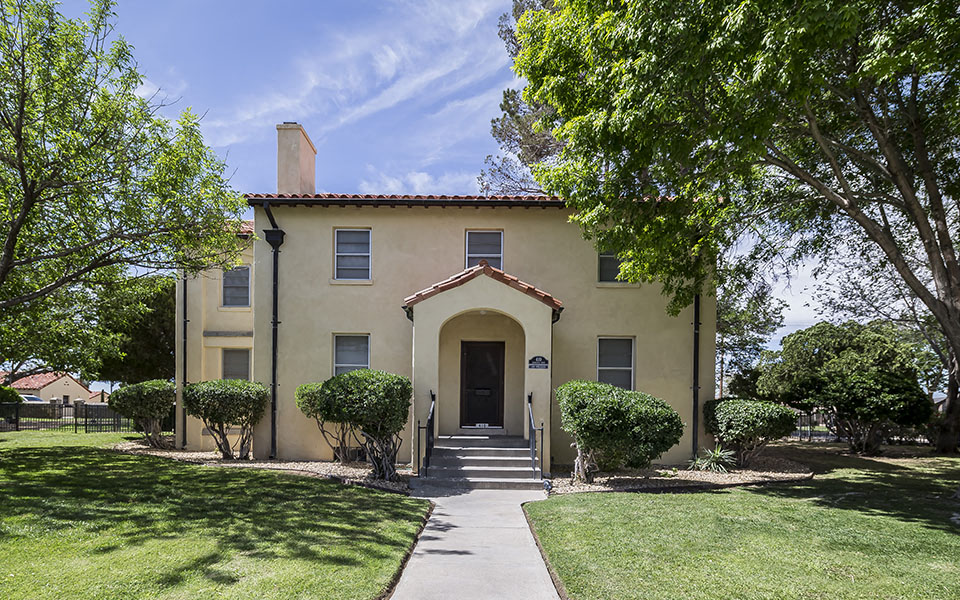 the front of a house with a sidewalk and trees