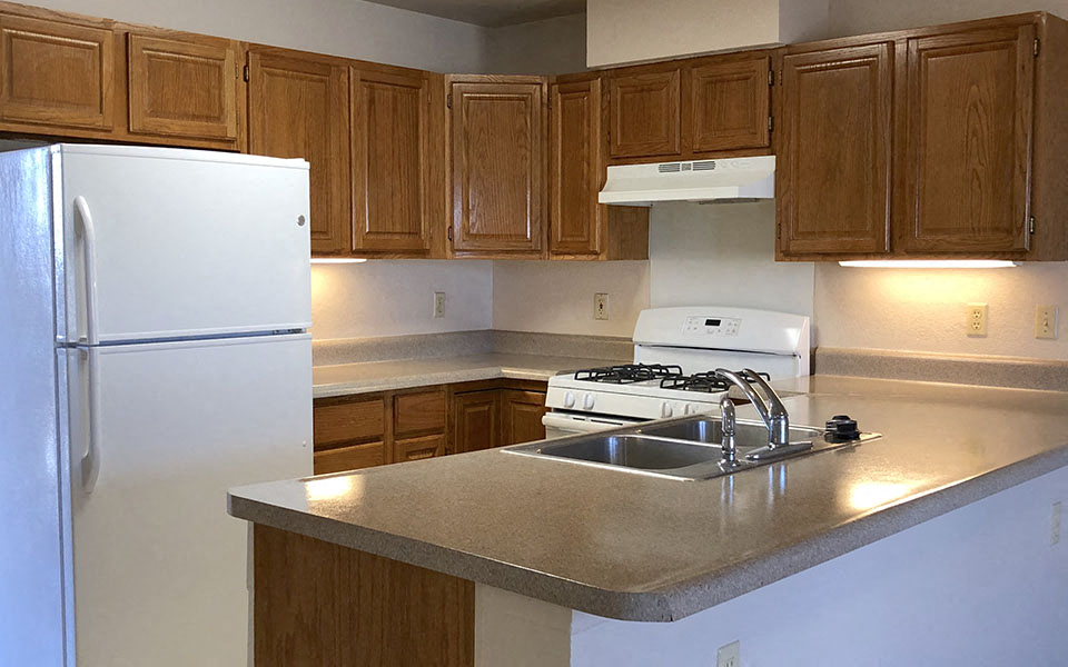 a kitchen with a sink a stove and a refrigerator