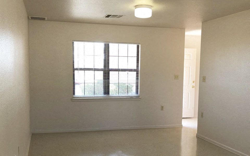 an empty living room with a large window in it