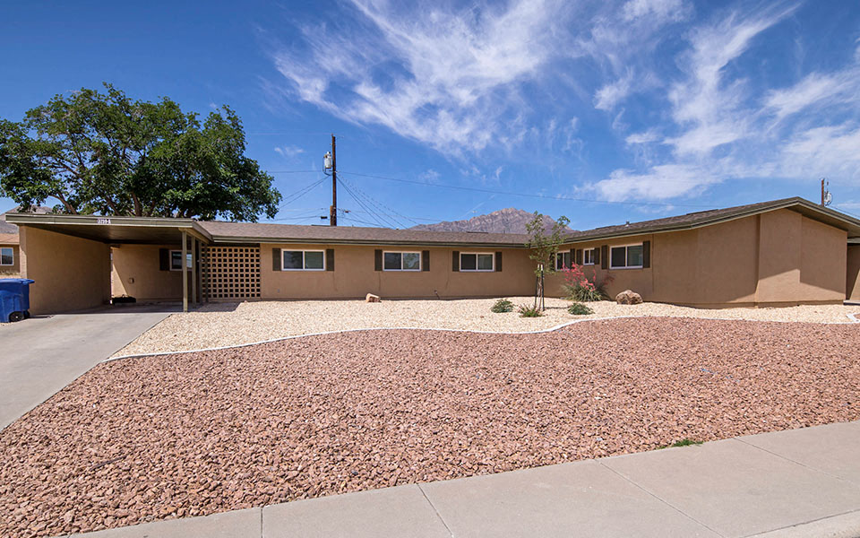 a house with a gravel yard and a driveway