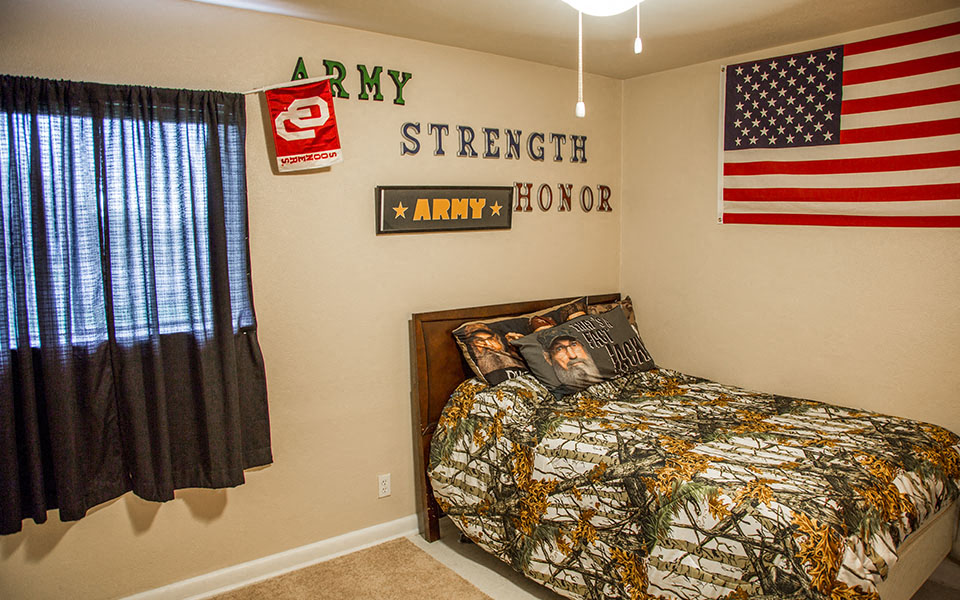 a bedroom with a bed and an flag on the wall