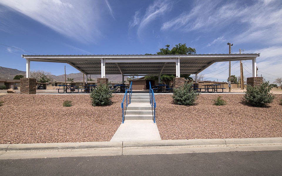 a covered pavilion with steps leading up to a picnic shelter