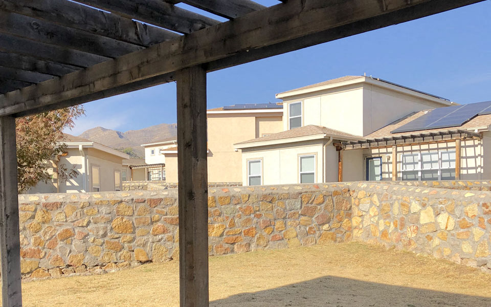 a view of a house from behind a stone wall