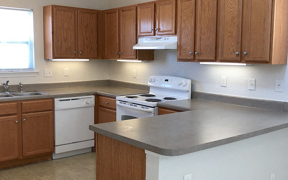 a kitchen with white appliances and wooden cabinets