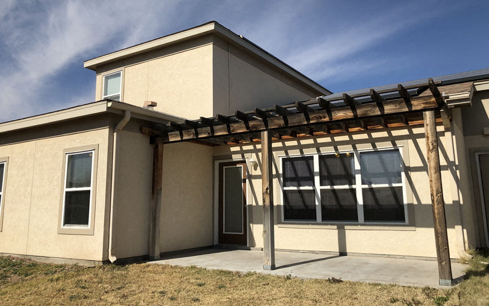 a house with a patio and awning in front of it