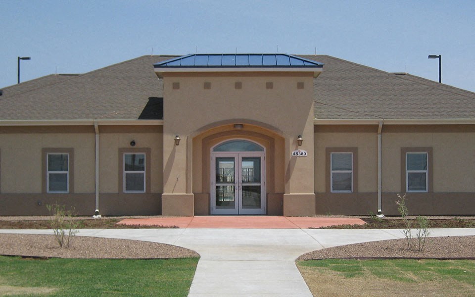 the front of a building with a walkway and a glass door