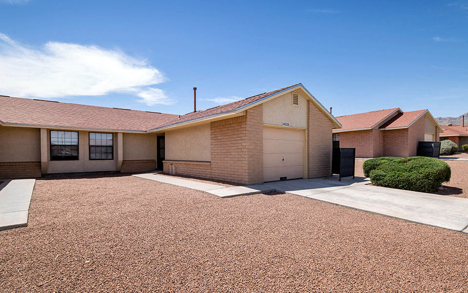 a brick house with a driveway and a garage door