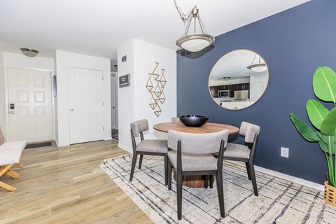 a dining room with a table and chairs and a blue wall