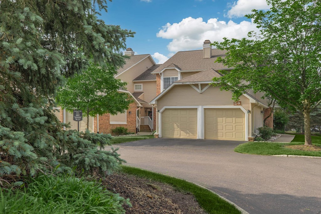 the front of a house with a driveway and garage doors