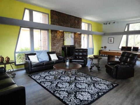 a living room with black leather furniture and yellow walls
