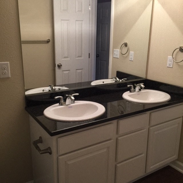 a bathroom with two sinks and a mirror
