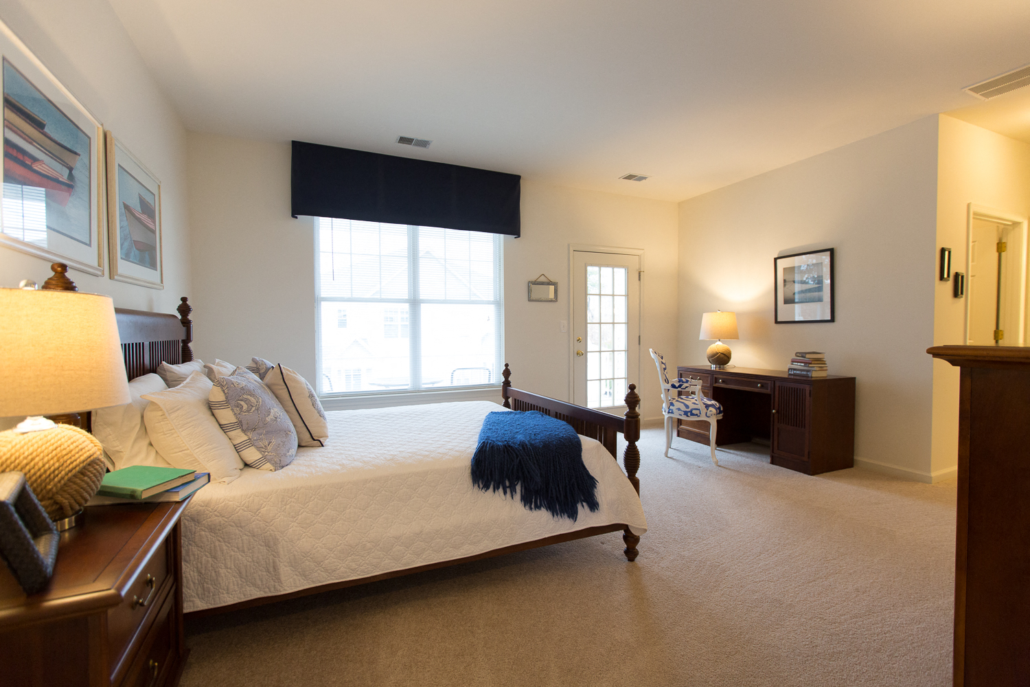 a bedroom with a bed and a desk and a window