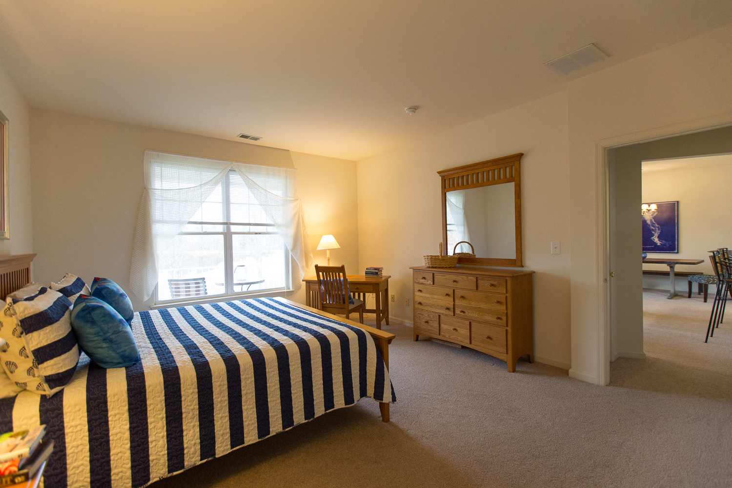 a bedroom with a bed and a dresser and a window