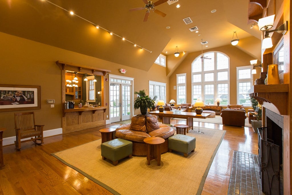 a large living room with a fireplace and a ceiling fan