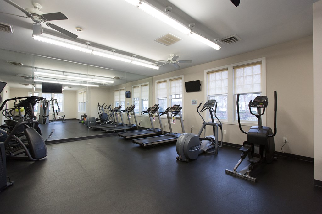 a gym with cardio machines and weights on the floor