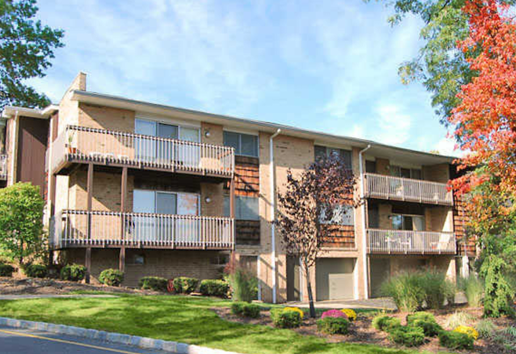 the exterior of an apartment building with balconies and a lawn