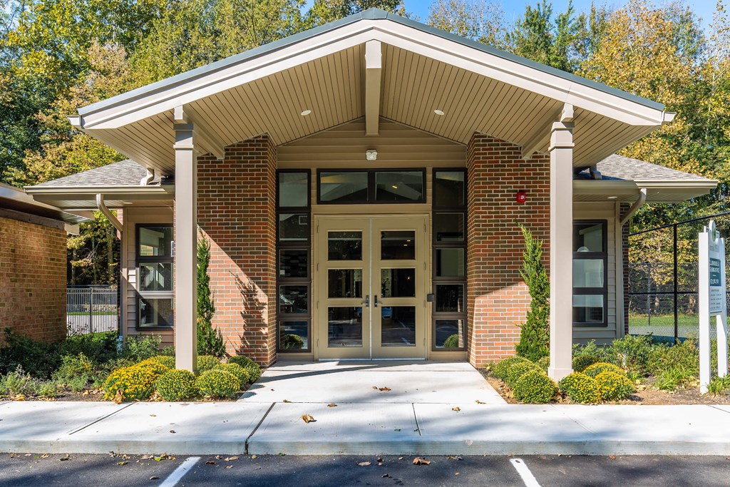 the front of a building with doors and a sidewalk