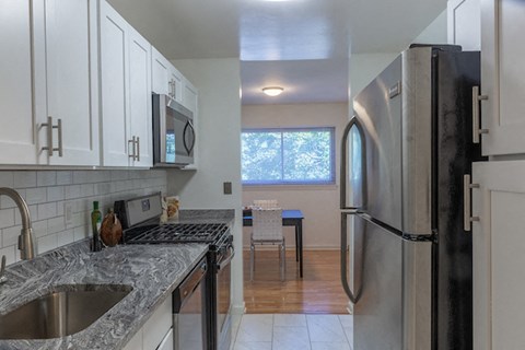 a kitchen with granite counter tops and a stainless steel refrigerator