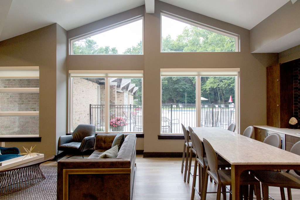 a large living room with large windows and a table and chairs