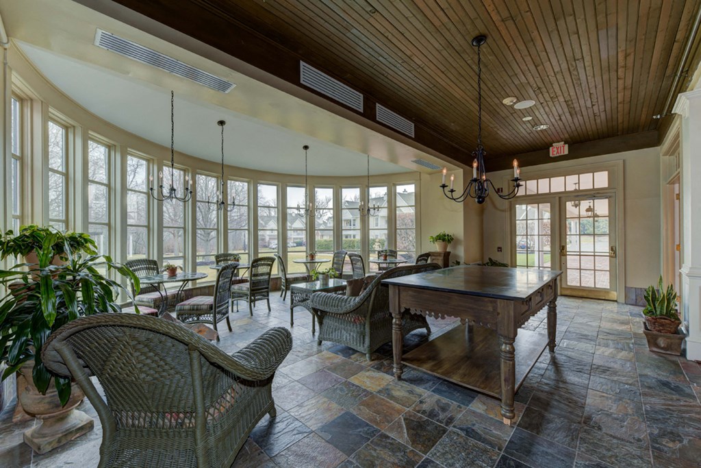 a dining room with a table and chairs and large windows