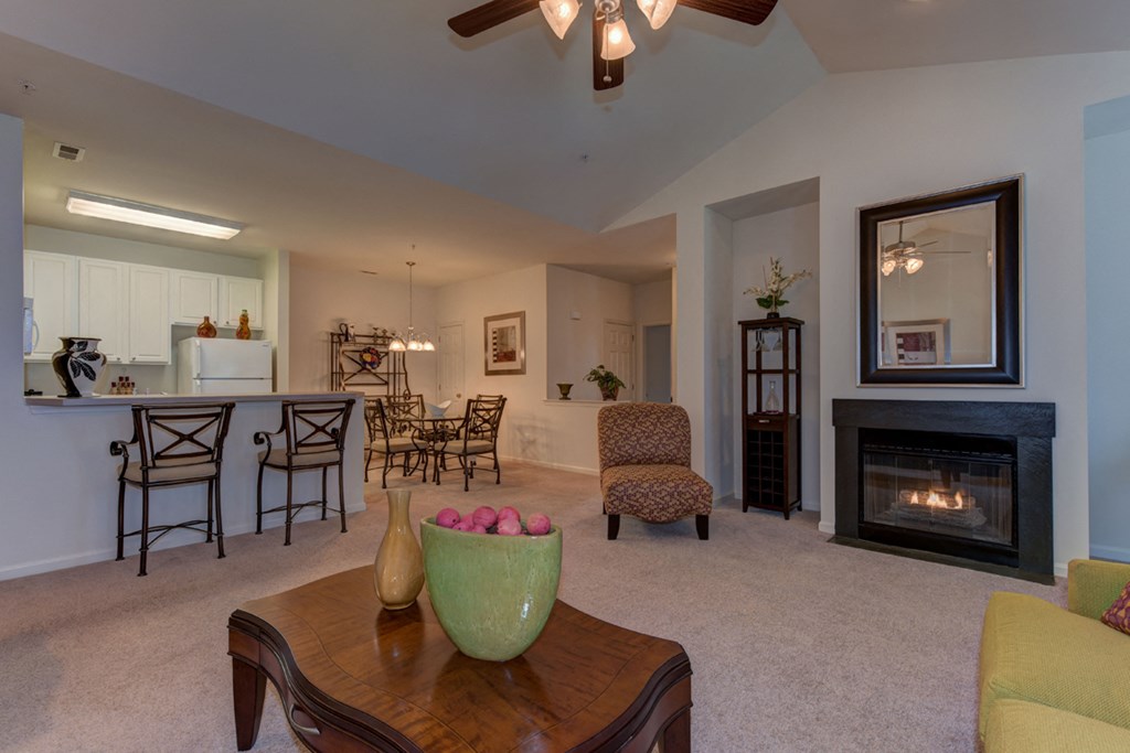 a living room with a fireplace and a table with a bowl of fruit
