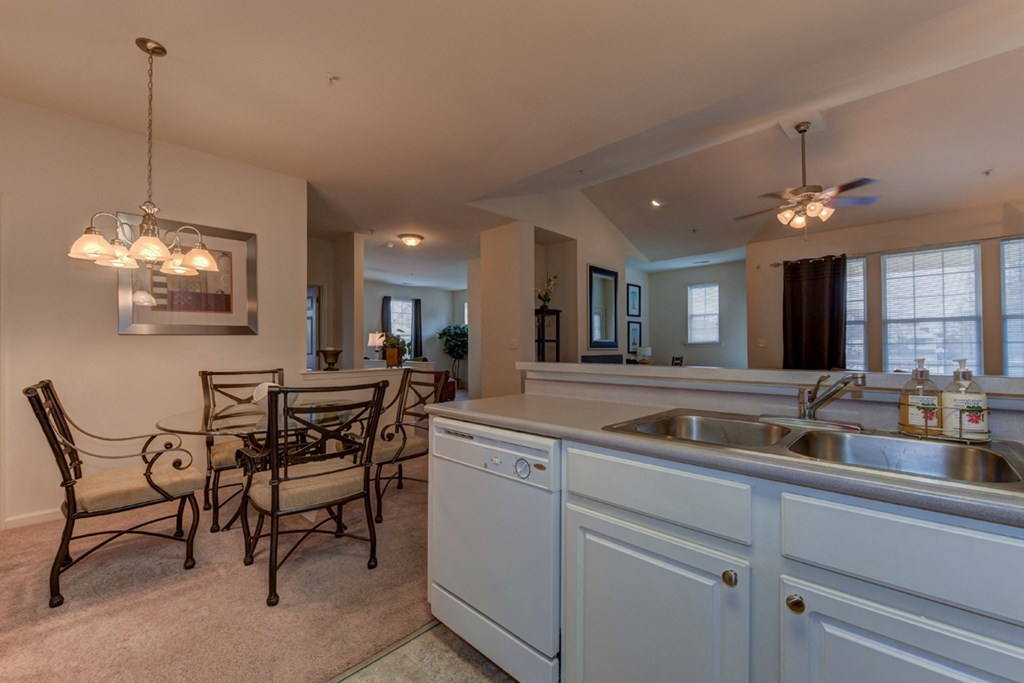 a kitchen and dining area with a table and chairs and a sink