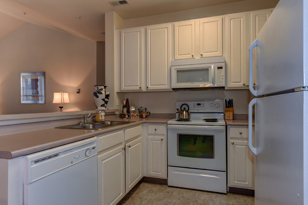a kitchen with white appliances and white cabinets
