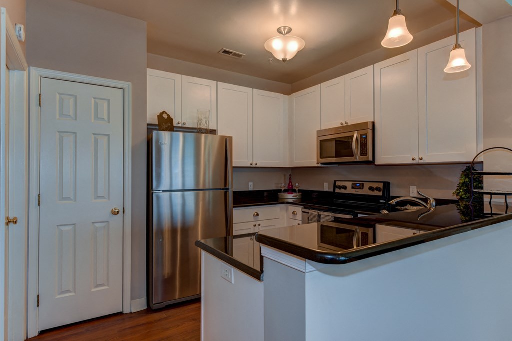 a kitchen with white cabinets and a stainless steel refrigerator