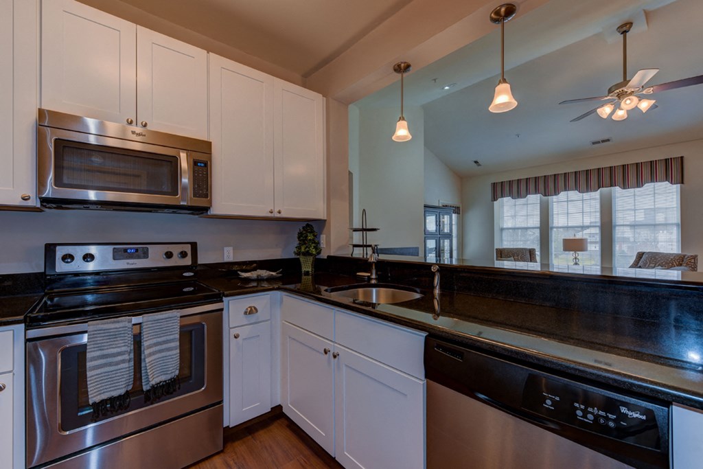 a kitchen with black counter tops and stainless steel appliances