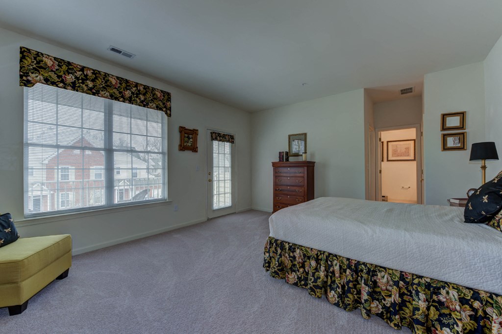 a bedroom with a bed and a large window