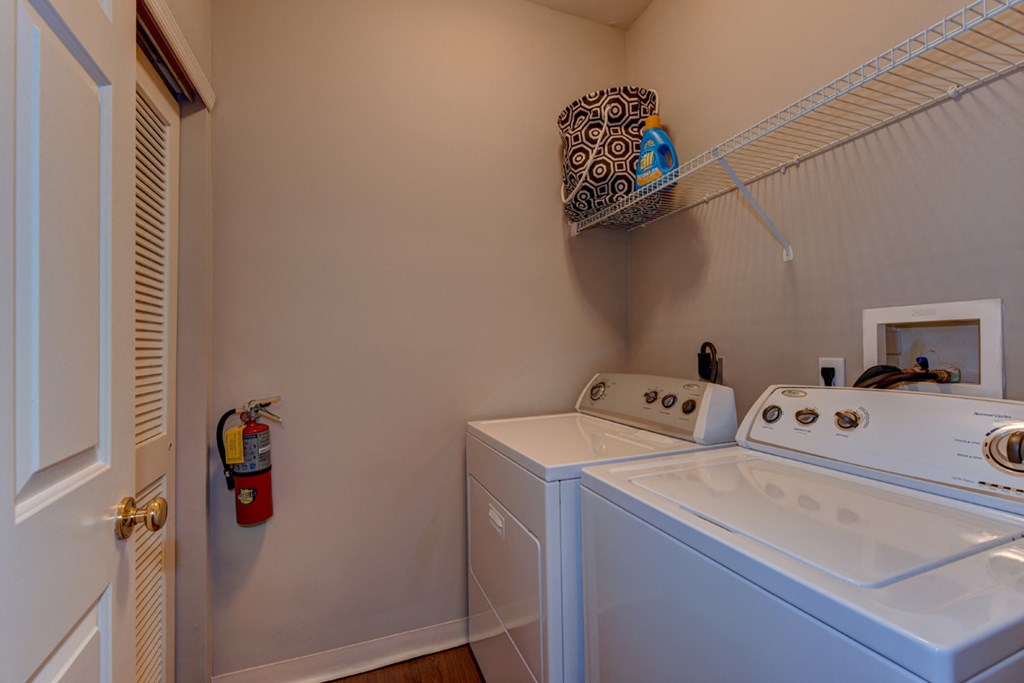 the laundry room has a washer and dryer and a door to the closet