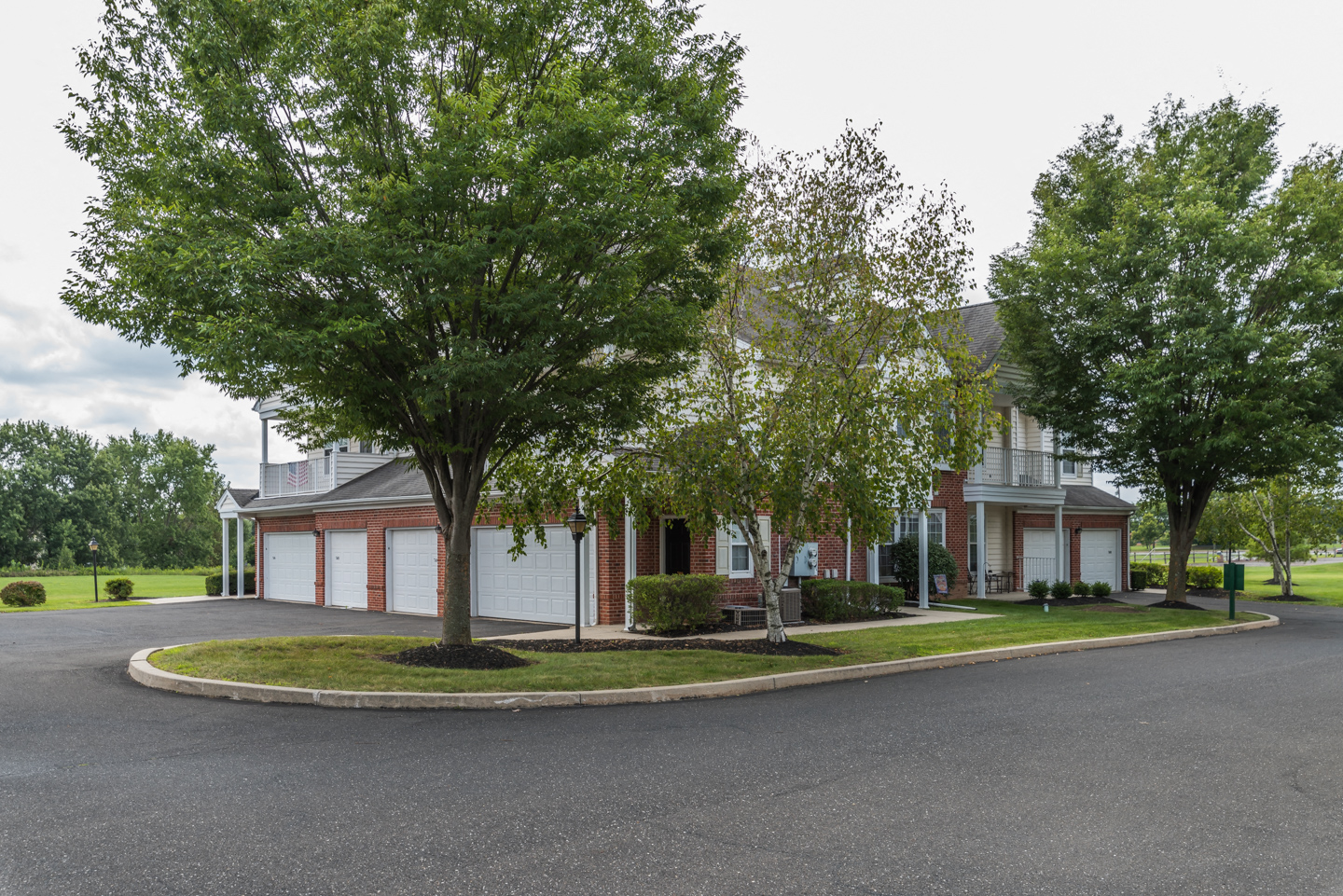 a tree lined street in front of a house