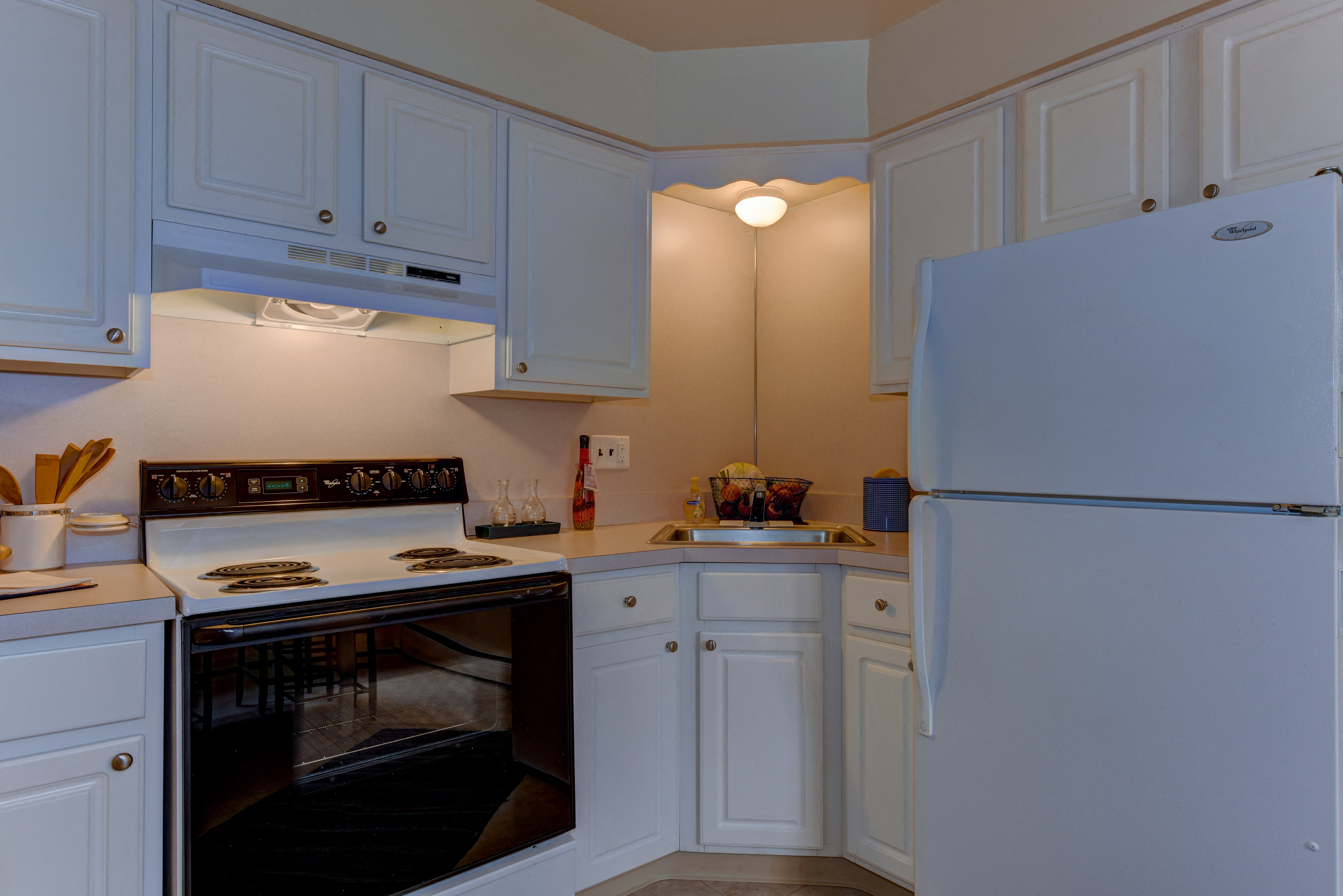 a kitchen with white cabinets and a white refrigerator