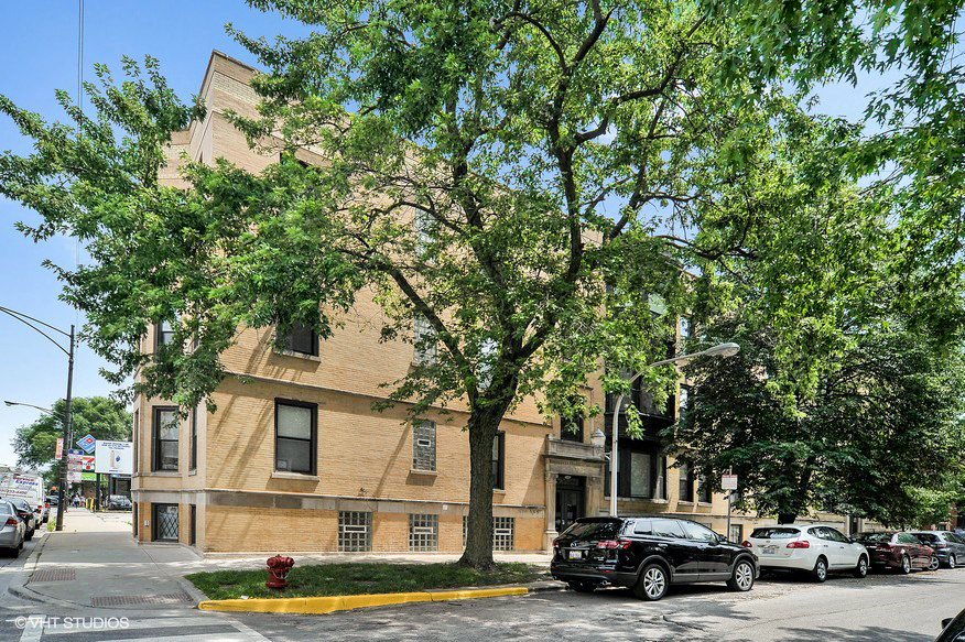 a large brick building with cars parked in front of it