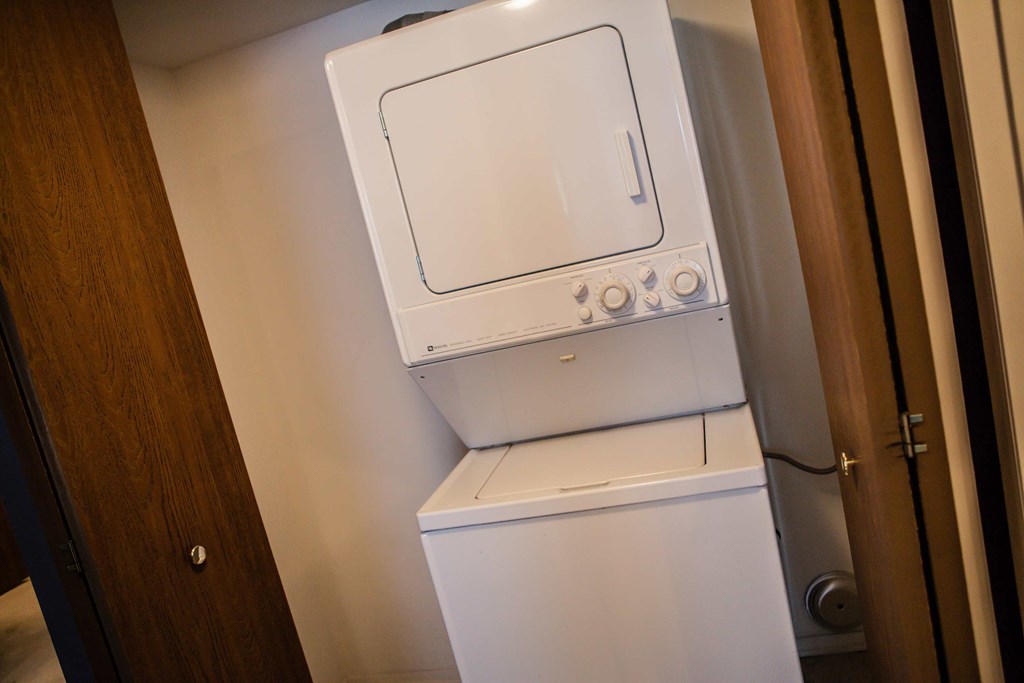 A white oven and microwave built into a kitchen cabinet.