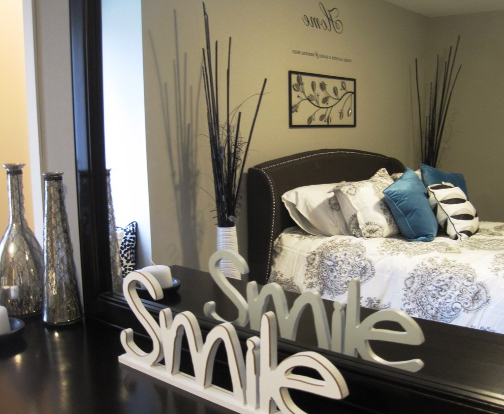 A bedroom with a bed and a sign that says "smile".